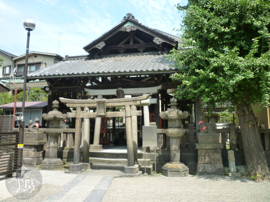Small shrine with two stone torii, two stone lanterns and two fox statues flanking them